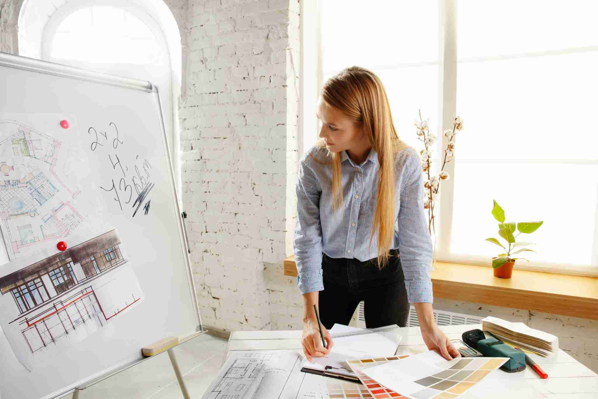 Professional interior designer working with colour palette and room drawings